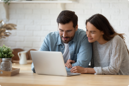 Couple sitting together while looking at laptop