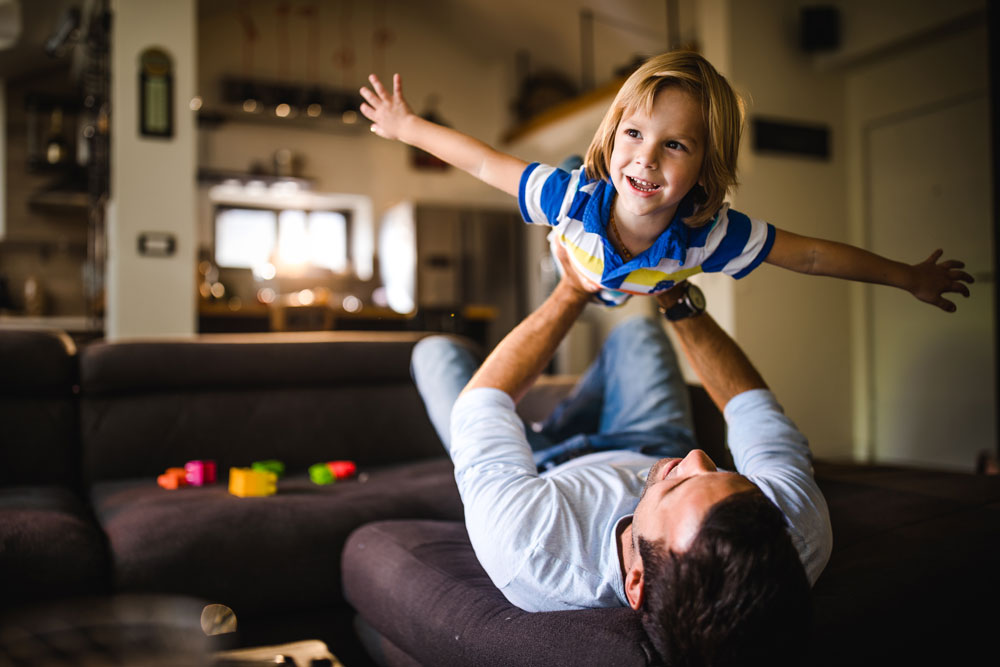 Hombre sosteniendo a un niño en el aire