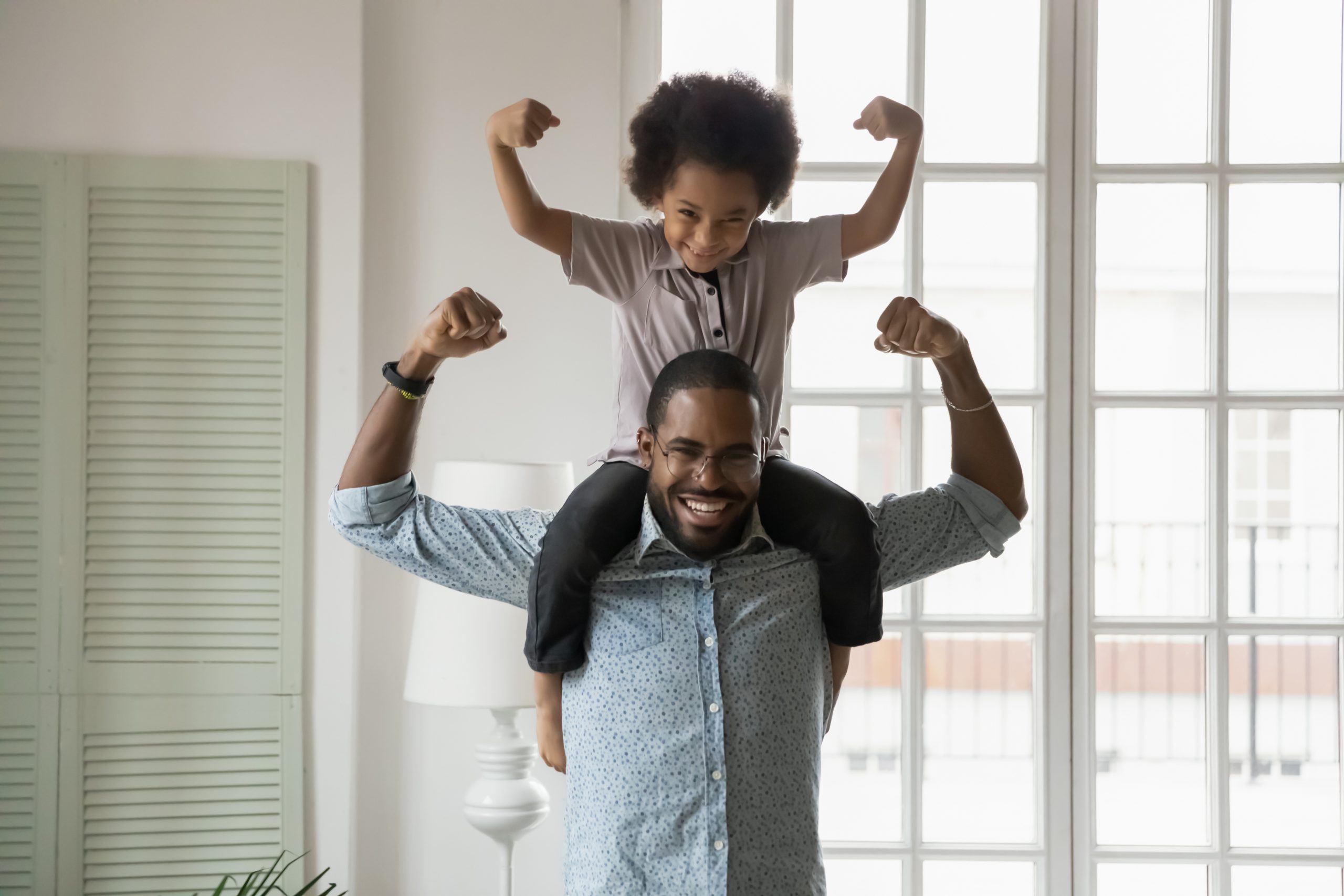 A father with his young son on his shoulders posing for a photo