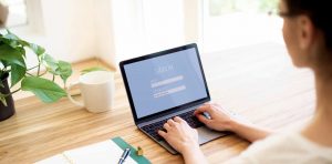 Woman signing into online account from laptop