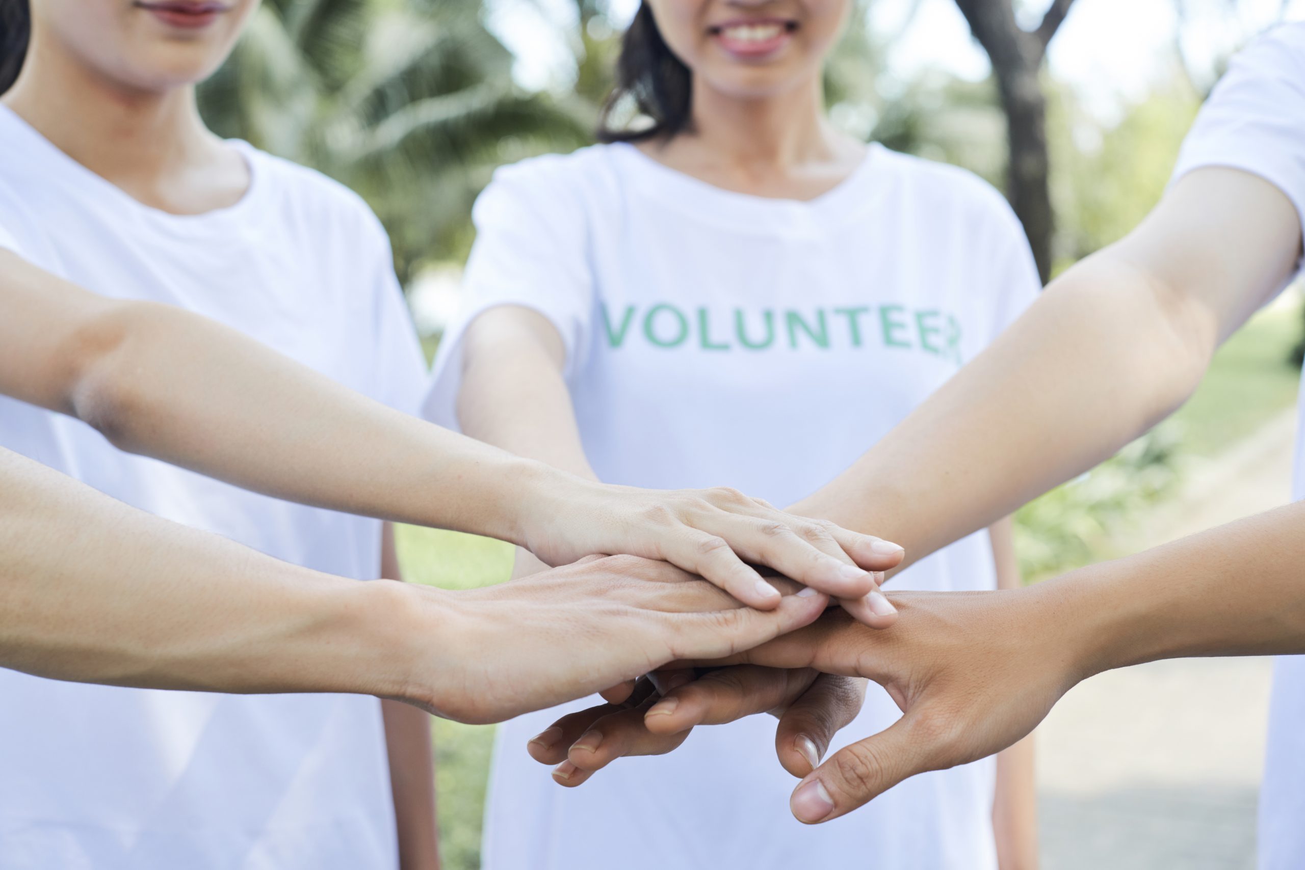 Group of volunteers stacking hands together