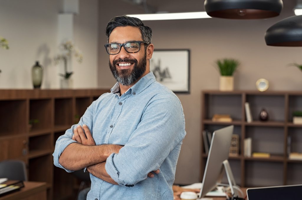 Man smiling while looking at camera with arms crossed