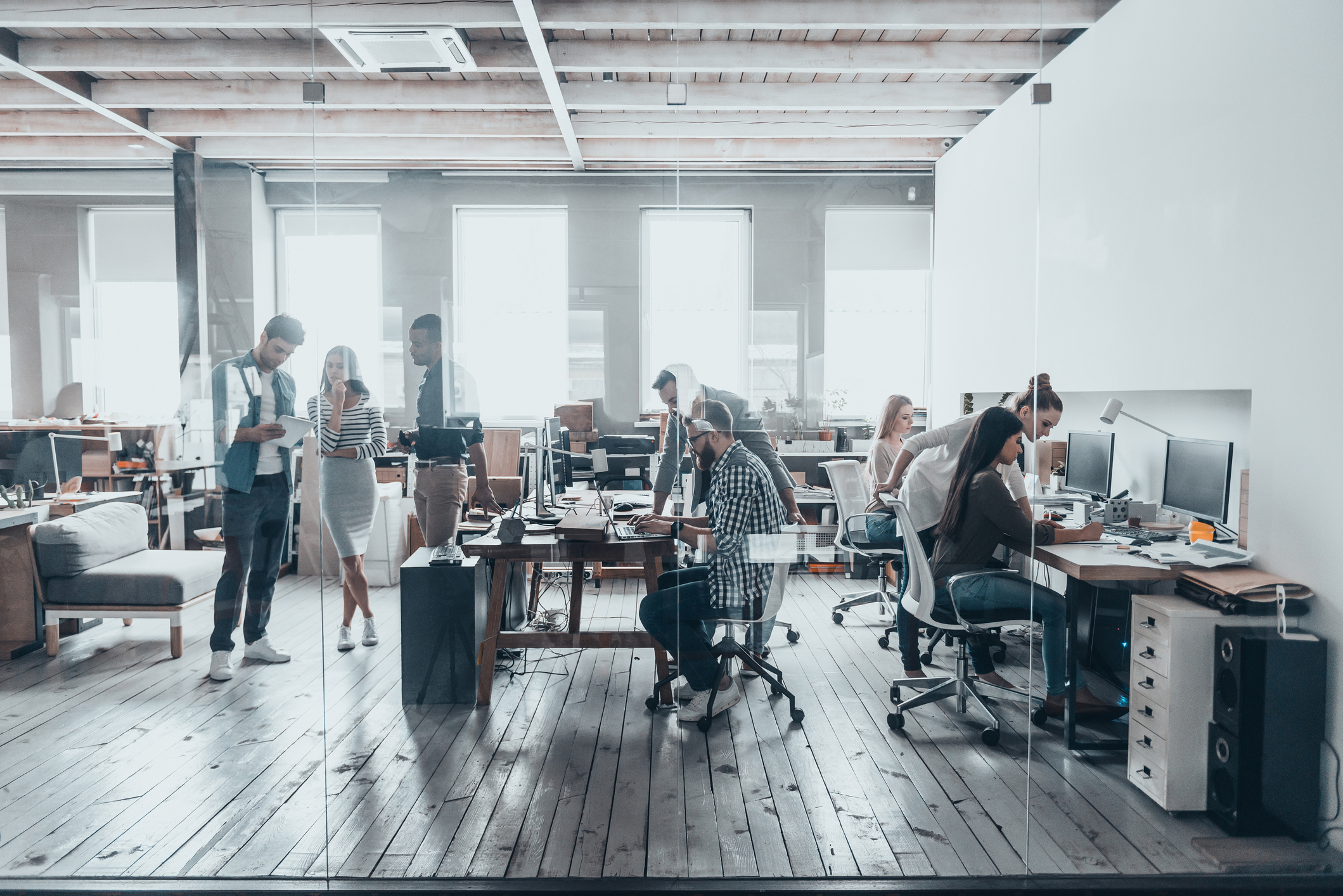 View of employees working at desks from outside of glass window