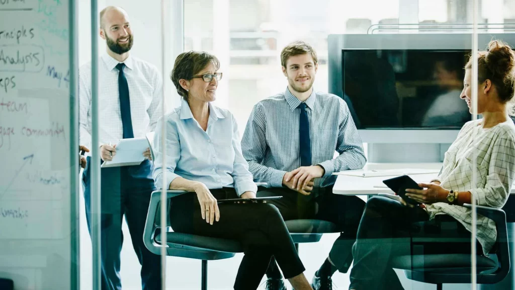 Group of 4 employees meeting in conference room