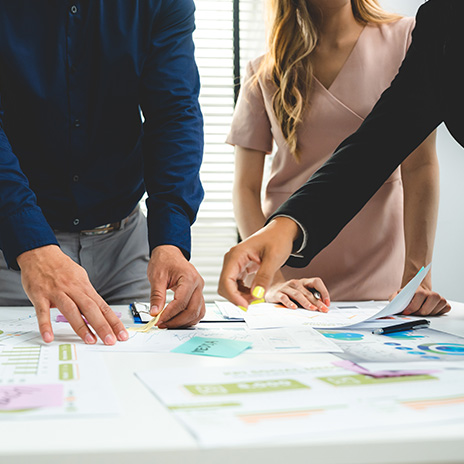 Group of coworkers in meeting looking through reports